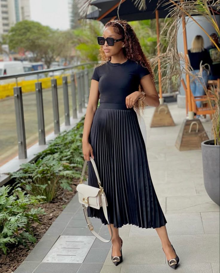 a high-waisted A-line or pleated midi skirt with a tucked-in tee or a structured blouse, summer outfit idea