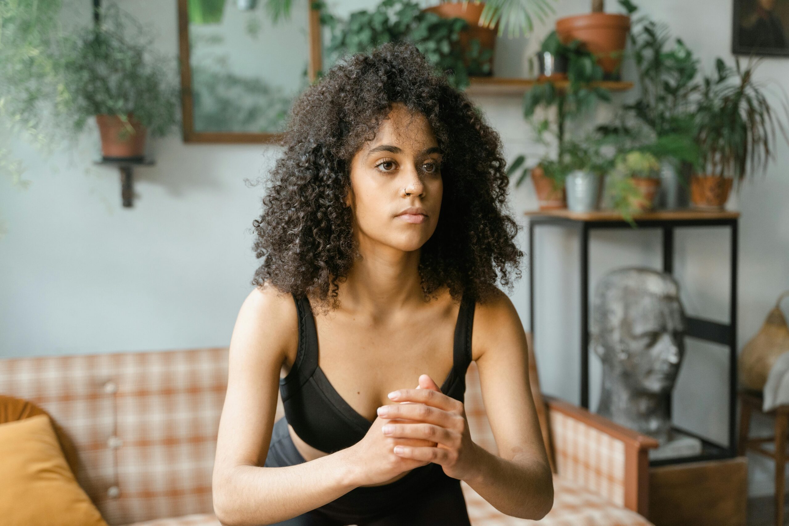 Woman working out joyfully at home during a faith-based workout session with worship music playing in the background