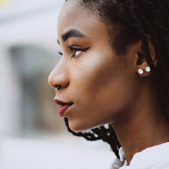 Close-up of a woman showing multiple piercings so should i get a tattoo and piercings?
