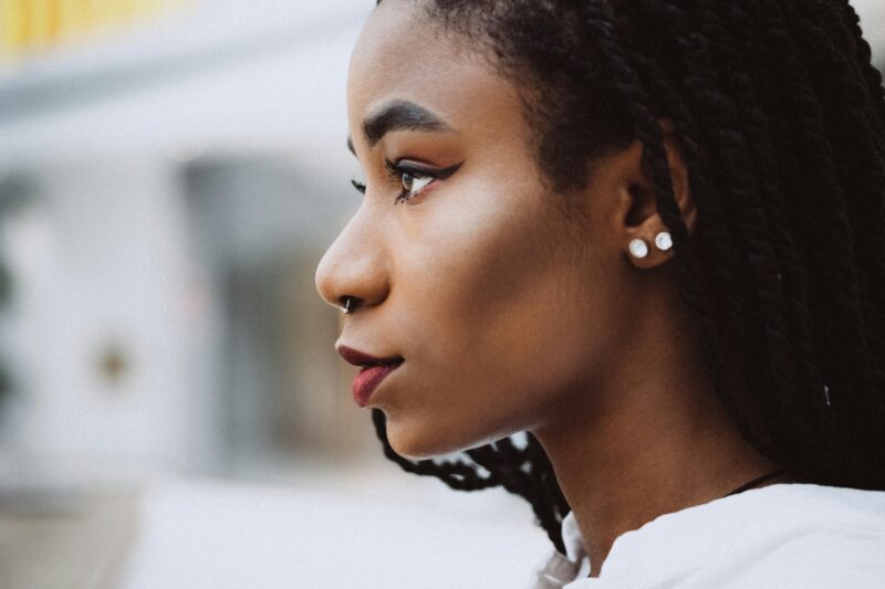 Close-up of a woman showing multiple piercings so should i get a tattoo and piercings?